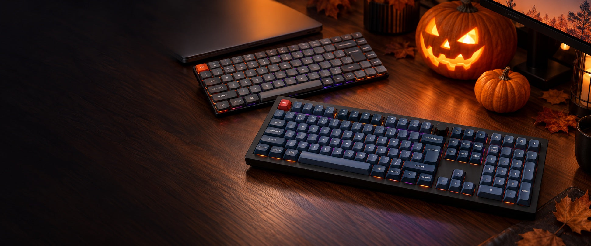 V6 Max and K3 Max keyboards on a dark desk with amber and violet lighting and Halloween pumpkins